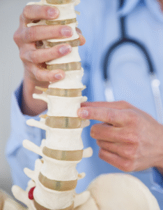chiropractor (1) Experienced chiropractor examining patient’s spine for pain relief in Tempe AZ
